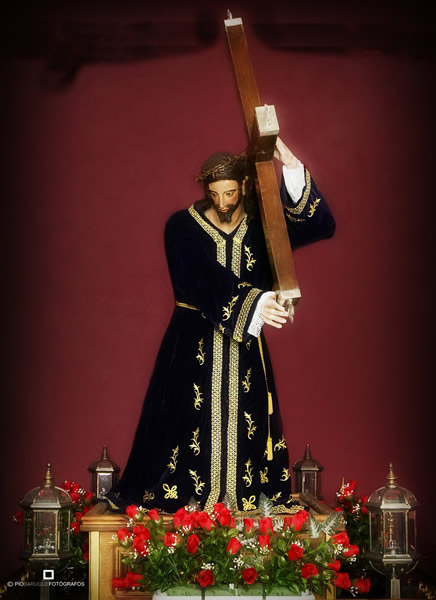 Representación de semana santa de Jesús sujetando la cruz